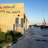 Risaliamo e accediamo attraverso un cancello al molo vero e proprio, il quale si allunga per circa 500 metri nel Mar Adriatico. La prima parte � occupata dal �nuovo� mercato del pesce, indicato da una grande scritta a forma di onda con lettere blu 